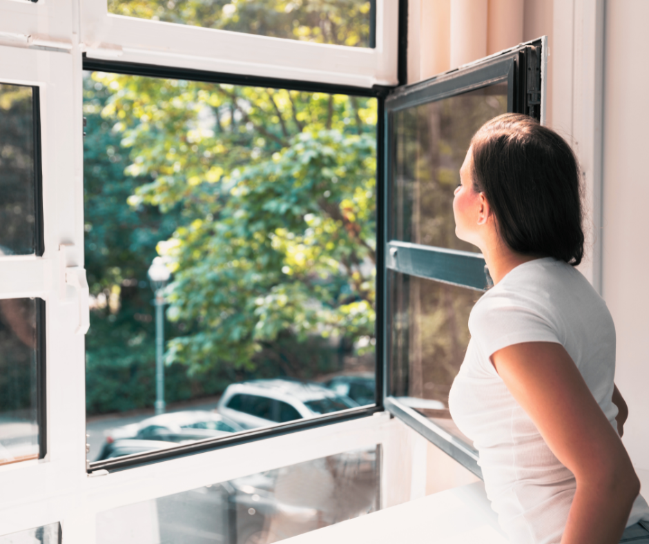A woman is looking outside by the window