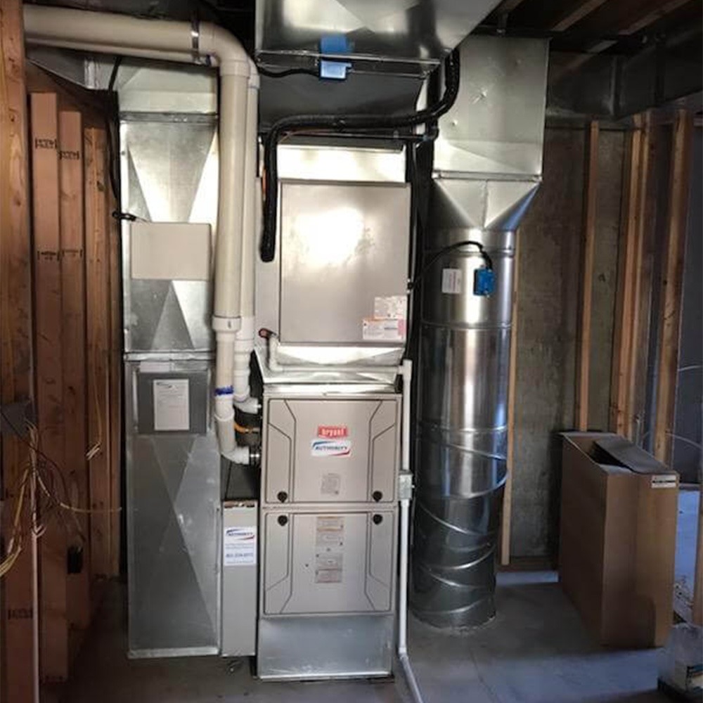 The image displays a Bryant HVAC system installed in a home's basement.