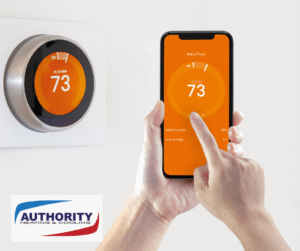 Smart thermostat image. A hand adjusts a digital thermostat on a smart phone, with a similar thermostat on the wall.